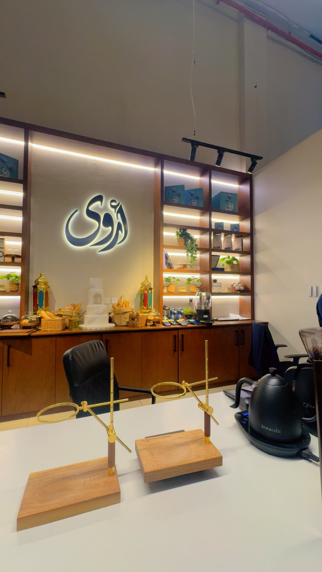 داخل أروى: رفوف خشب وشعار مضيء على الجدار